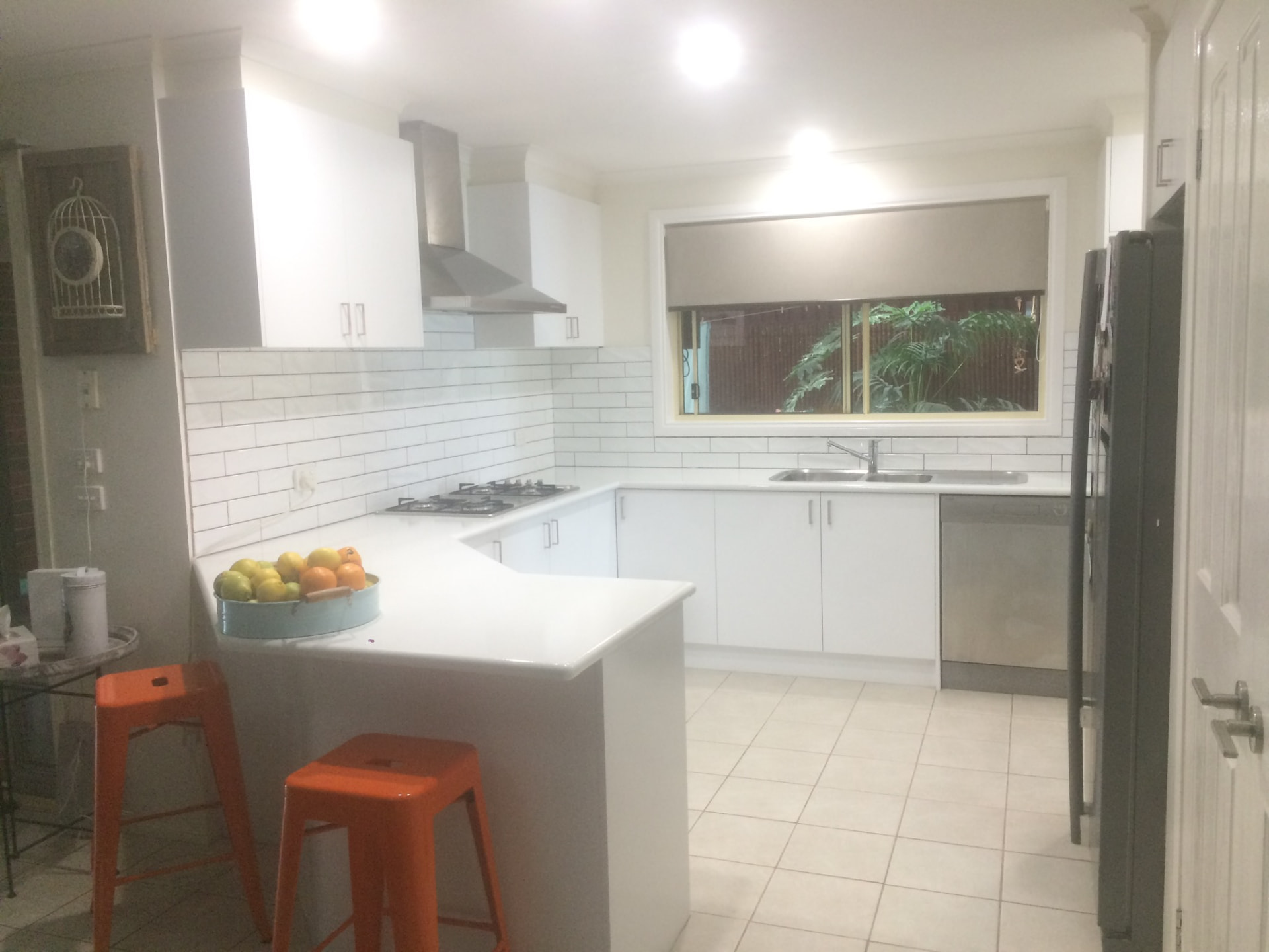 Resurfaced U-shaped white kitchen with breakfast bar